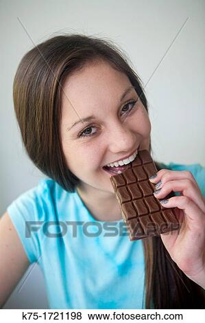 Teen girl eating dark chocolate View Large Photo Image Stock Photo - Teen girl eating dark chocolate. Fotosearch