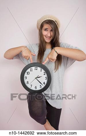 Teen girl holding a wall clock View Large Photo Image Stock Image - Teen girl holding a wall clock. Fotosearch
