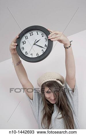 Teen girl holding a wall clock View Large Photo Image Stock Image - Teen girl holding a wall clock. Fotosearch