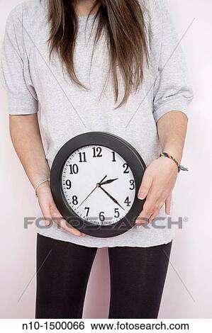 Teen girl holding a wall clock View Large Photo Image Stock Photograph - Teen girl holding a wall clock. Fotosearch