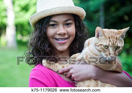 Stock Photograph - Teen girl holding cat. Fotosearch