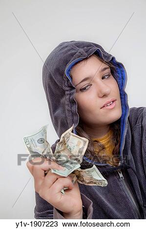 Stock Image - Teen girl holding United States money. Fotosearch