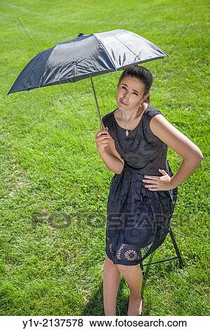 Teen girl, in a park, holding an umbrella. View Large Photo Image Stock Photo - Teen girl, in a park, holding an umbrella.. Fotosearch