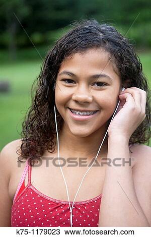 Teen girl listening to music on her mp3 player View Large Photo Image Stock Image - Teen girl listening to music on her mp3 player. Fotosearch