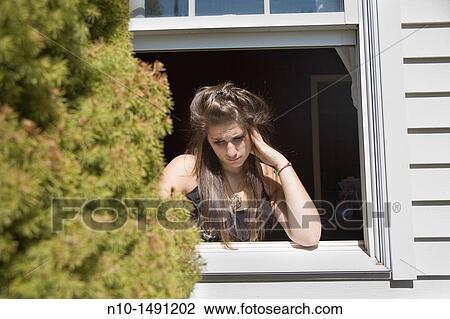 Teen girl looking out her house window View Large Photo Image Stock Image - Teen girl looking out her house window. Fotosearch