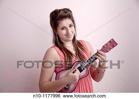 Teen girl playing a ukulele View Large Photo Image Stock Photograph - Teen girl playing a ukulele. Fotosearch