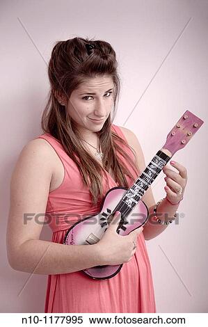Stock Photography - Teen girl playing a ukulele. Fotosearch