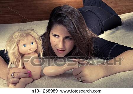 Teen girl pulling apart her doll View Large Photo Image Stock Photo - Teen girl pulling apart her doll. Fotosearch