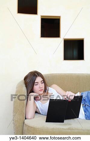 Stock Image - Teen girl reading a book. Fotosearch