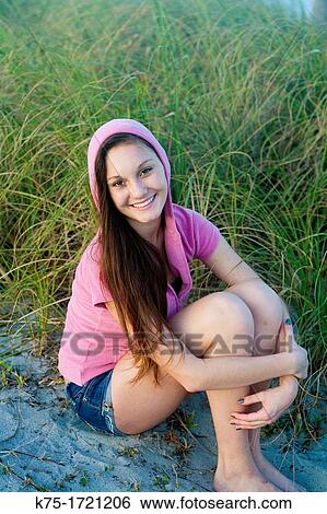 Teen girl sitting in beach grass View Large Photo Image Stock Photograph - Teen girl sitting in beach grass. Fotosearch
