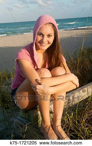 Teen girl sitting on fence in sand dune View Large Photo Image Stock Photography - Teen girl sitting on fence in sand dune. Fotosearch