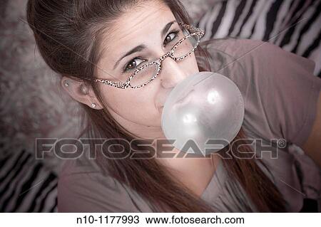 Teen girl, sitting on her bed, blowing bubbles View Large Photo Image Stock Image - Teen girl, sitting on her bed, blowing bubbles. Fotosearch