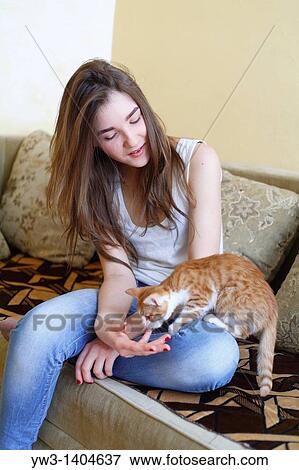 Teen girl sitting on sofa at home with kitty View Large Photo Image Stock Photo - Teen girl sitting on sofa at home with kitty. Fotosearch