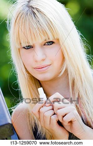 Teen girl with a mouth protective lipstick in hand View Large Photo Image Stock Image - Teen girl with a mouth protective lipstick in hand. Fotosearch