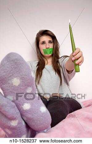 Teen girl with tape over her mouth, holding a lit candle View Large Photo Image Stock Photo - Teen girl with tape over her mouth, holding a lit candle. Fotosearch