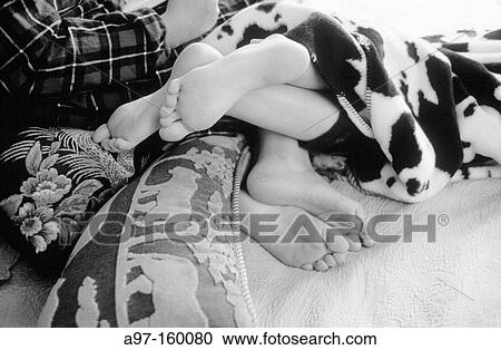 Stock Image - Teen girl's feet entwined. Fotosearch
