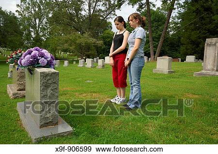 Teen girls mourn the loss of a family member The young ladies gaze sadly at the headstone of the one they love View Large Photo Image Stock Photo - Teen girls mourn the loss of a family member The young ladies gaze sadly at the headstone of the one they love. Fotosearch