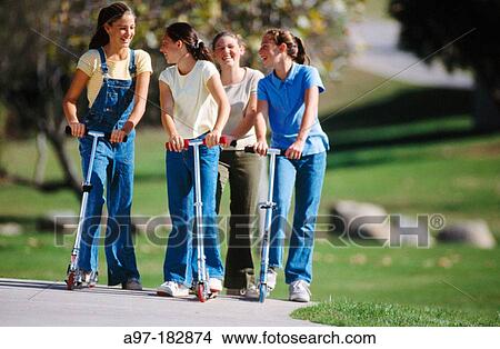 Picture - Teen girls on scooters. Fotosearch