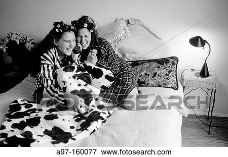 Stock Photo - Teen girls talk on phone in bedroom. Fotosearch