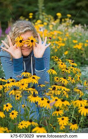 Teen holding wildflowers on her eyes View Large Photo Image Stock Photo - Teen holding wildflowers on her eyes. Fotosearch