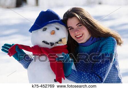 Stock Photo - Teen hugging snowman. Fotosearch
