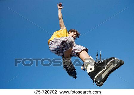 Stock Image - Teen jumping with rollerblades. Fotosearch