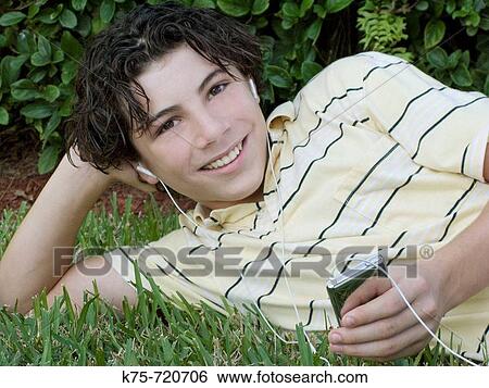 Stock Photograph - teen listening to MP3 player outdoors. Fotosearch