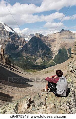 Teen looking at a mountain valley view View Large Photo Image Stock Photo - Teen looking at a mountain valley view. Fotosearch