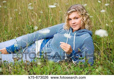 Teen lying in field of wildflowers View Large Photo Image Stock Photograph - Teen lying in field of wildflowers. Fotosearch