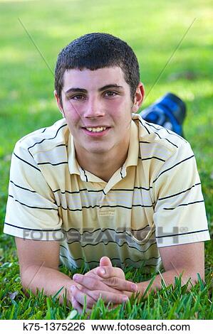 Stock Photograph - teen lying on lawn. Fotosearch