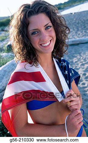 Stock Image - Teen on beach with US flag. Fotosearch