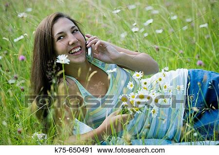 Teen on cell phone outdoors View Large Photo Image Stock Image - Teen on cell phone outdoors. Fotosearch