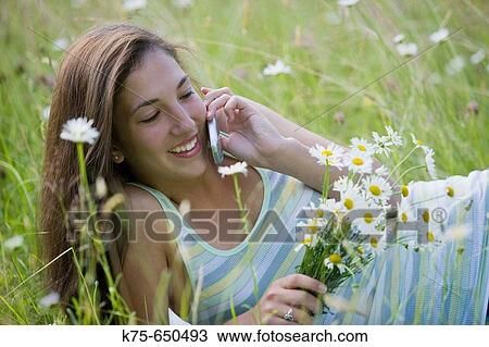 Stock Image - Teen on cell phone outdoors. Fotosearch