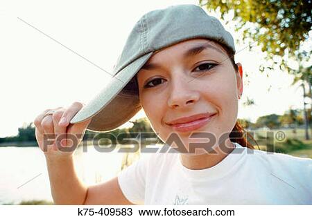 Stock Image - Teen playing with her cap. Fotosearch