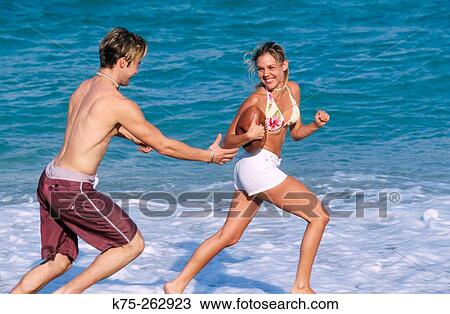 Teen running with a football on beach View Large Photo Image Stock Image - Teen running with a football on beach. Fotosearch