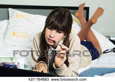 Teen schoolgirl doing homework in her bedroom View Large Photo Image Stock Image - Teen schoolgirl doing homework in her bedroom. Fotosearch