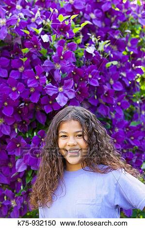 Teen standing in front of Clematis flowers View Large Photo Image Stock Image - Teen standing in front of Clematis flowers. Fotosearch