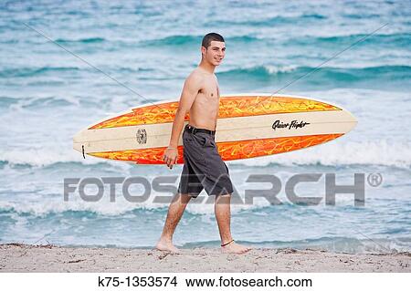 Teen surfer with his surfboard View Large Photo Image Picture - Teen surfer with his surfboard. Fotosearch