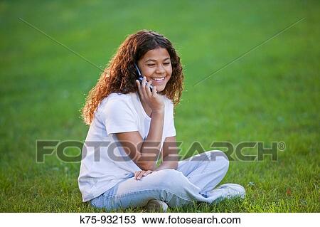 Teen talking on cell phone outdoors View Large Photo Image Stock Image - Teen talking on cell phone outdoors. Fotosearch
