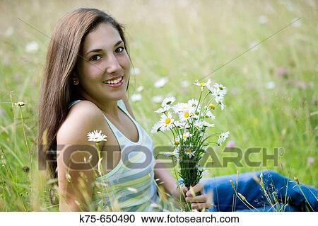 Stock Image - Teen with bouquet of daisies. Fotosearch