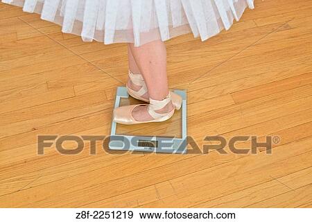 Stock Photo - Teen with pointe ballet shoes standing on weight scale.. Fotosearch
