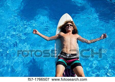 Teenage boy chilling on his surfboard View Large Photo Image Stock Photo - Teenage boy chilling on his surfboard. Fotosearch