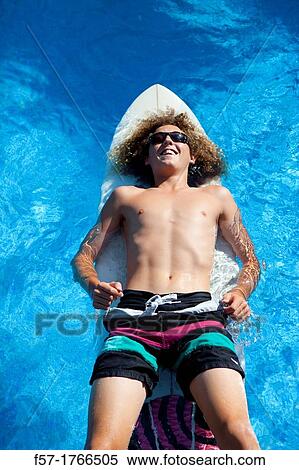 Teenage boy chilling on his surfboard View Large Photo Image Stock Photography - Teenage boy chilling on his surfboard. Fotosearch