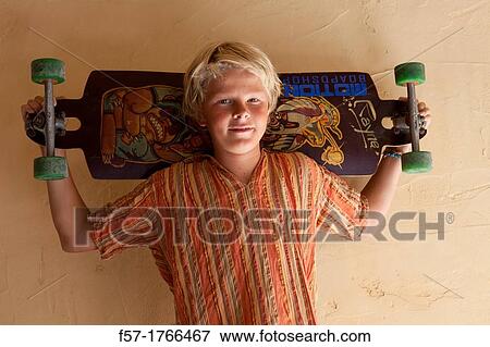 Teenage boy holding a long board View Large Photo Image Stock Photo - Teenage boy holding a long board. Fotosearch
