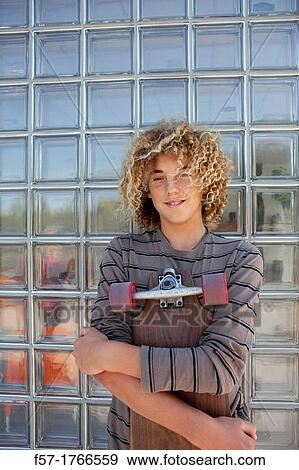 Stock Photo - Teenage boy holding a long board. Fotosearch
