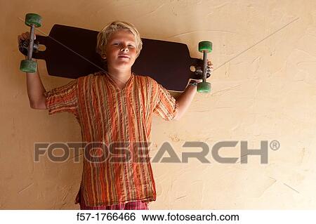 Teenage boy holding a long board View Large Photo Image Stock Photograph - Teenage boy holding a long board. Fotosearch