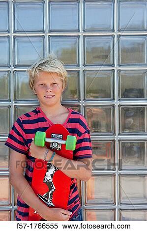 Teenage boy holding a long board View Large Photo Image Stock Photography - Teenage boy holding a long board. Fotosearch