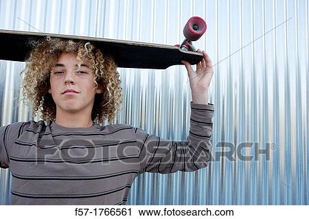 Teenage boy holding a longboard on his head View Large Photo Image Stock Image - Teenage boy holding a longboard on his head. Fotosearch