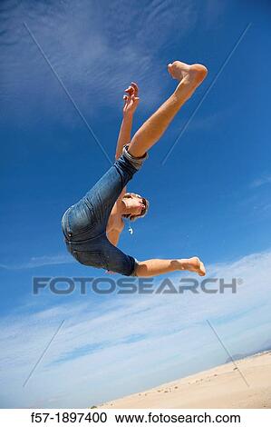 Teenage boy jumping in the air over the dunes View Large Photo Image Stock Image - Teenage boy jumping in the air over the dunes. Fotosearch