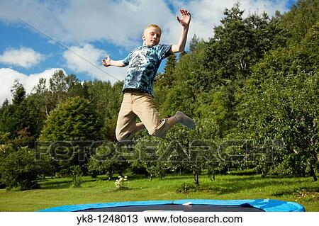 Stock Image - Teenage Boy Jumping on Trampoline. Fotosearch